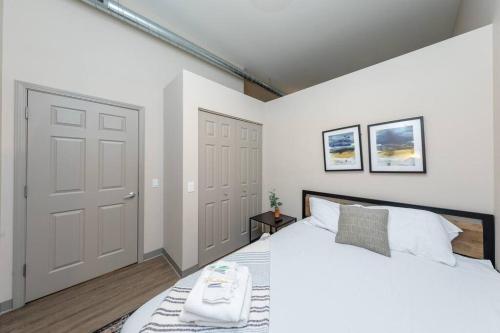 een witte slaapkamer met een groot wit bed en 2 deuren bij McCormick 2br/2ba Oasis with optional Parking, Patio, Gym for up to 6 guests in Chicago