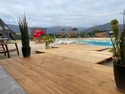 uma piscina com um deque de madeira ao lado de um resort em Parcela en Olmué. em Olmué