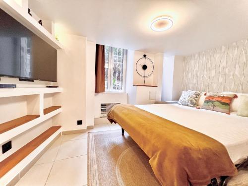 une chambre avec un grand lit et une télévision à écran plat dans l'établissement * Duplex Roassal * Modern *Clim * WiFi *Liberation, à Nice