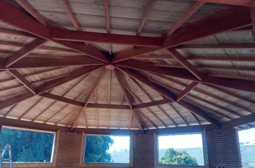 a large wooden ceiling in a room with windows at Pousada Sons do Silêncio in Socorro