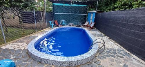 a hot tub in a backyard with a fence at Cabaña Vistas del Bosque piscina privada in Jarabacoa