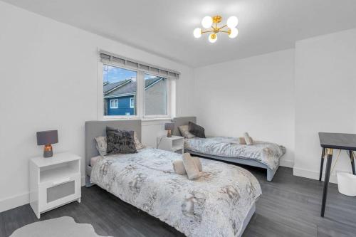 a bedroom with two beds and a window at West Lothian 5 Beds + car space in Whitburn
