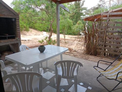 una mesa blanca y sillas en un patio en Los Caranchos II, en Cuchilla Alta