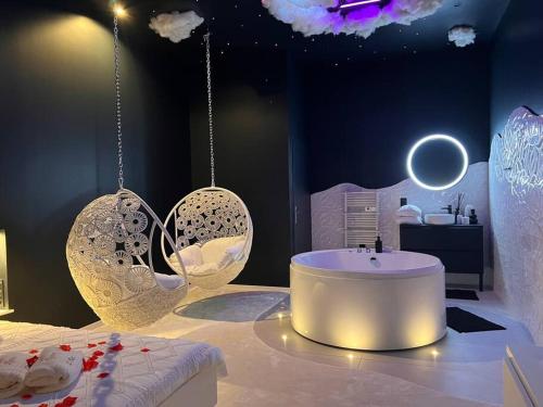 Zimmer mit Badewanne, Waschbecken und Beleuchtung in der Unterkunft Loving room cocooning l’Air in Jujurieux