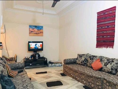 - un salon avec deux canapés et une télévision dans l'établissement ياقوت, à Erfoud