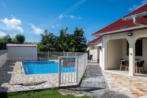 a swimming pool in the yard of a house at Maliann, T2+ à 5 min de la plage in Sainte-Anne