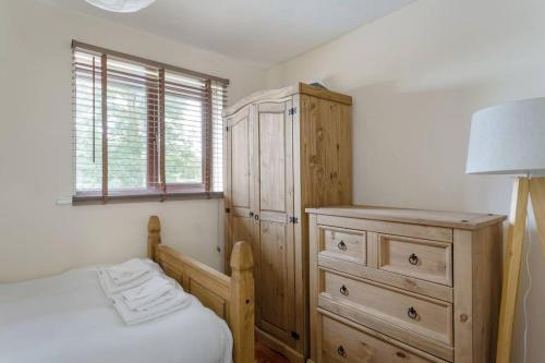 a bedroom with a dresser and a bed and a cabinet at Quiet & Secluded St Albans House in St. Albans
