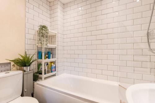 biała łazienka z wanną i toaletą w obiekcie Quiet & Secluded St Albans House w Saint Albans