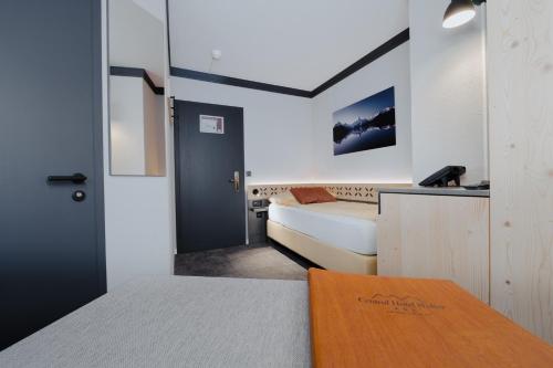 a small room with a table and a kitchen at Hotel Central Wolter - Grindelwald in Grindelwald
