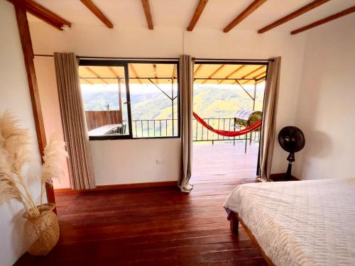 1 dormitorio con puerta que da a un balcón en Ecohotel Sereni Norcasia, en Samaná