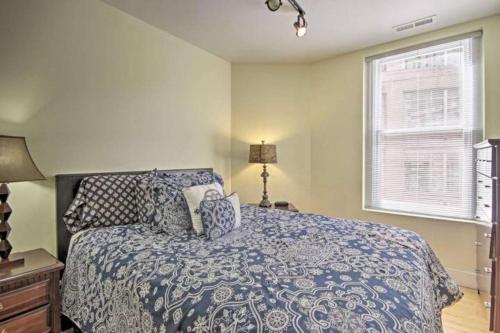 a bedroom with a bed with a blue comforter and a window at Chase Apartments Light St Convention Center FREE PARKING in Baltimore