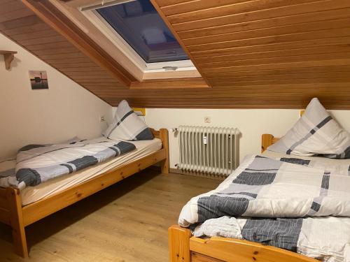 two beds in a room with a skylight at FeWo Gipfelglück in Willingen