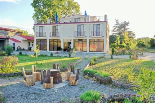 una casa con un montón de postes de madera delante de ella en Kisi Garden Hotel, en Telavi