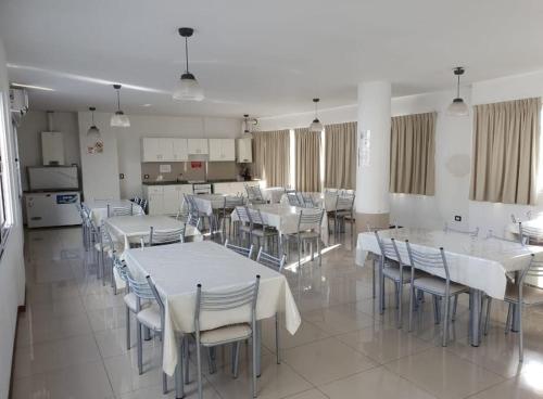 a dining room with white tables and chairs at Departamento San José IV- Villa Carlos Paz in Villa Carlos Paz
