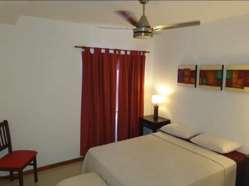 a bedroom with a bed and a red curtain at Departamento San José IV- Villa Carlos Paz in Villa Carlos Paz