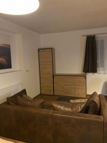 a living room with a brown couch and a stage at Apart Larcher in Arzl im Pitztal
