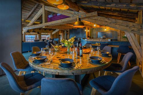 a dining room with a large wooden table and chairs at Chalet Melussac - OVO Network in Le Grand-Bornand