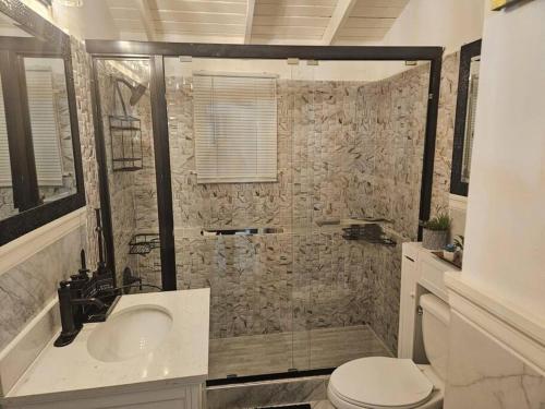 Un baño con ducha, lavabo e inodoro. en Cherr-ific Getaway Villa, en Falmouth
