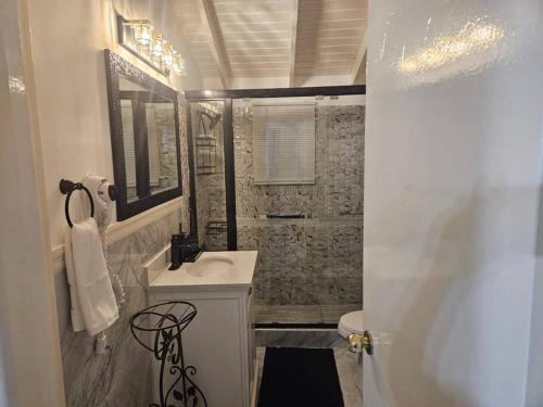y baño con lavabo blanco y ducha. en Cherr-ific Getaway Villa, en Falmouth