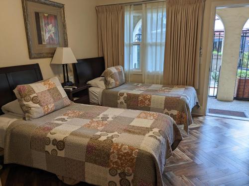 a hotel room with two beds and a window at Los Gatos Garden Inn Hotel in Los Gatos