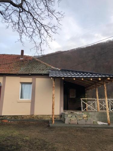 a house with a gambrel roof on top of it at Golubović Apartman in Crni Vrh