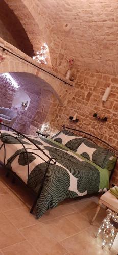 ein großes Bett in einem Zimmer mit Ziegelwand in der Unterkunft Dimora Cleó in Putignano