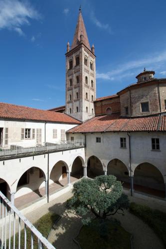 a building with a clock tower and a bridge at Hotel San Giovanni Resort in Saluzzo