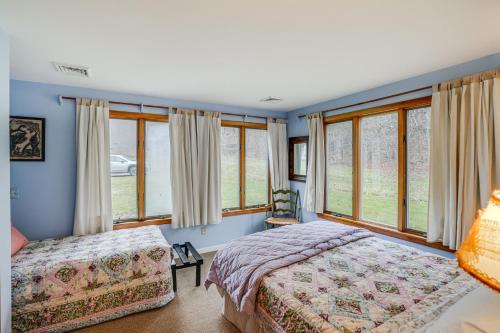 a bedroom with two beds and large windows at Hawley Home with Deck 4 Mi to Berkshire East Resort in Hawley
