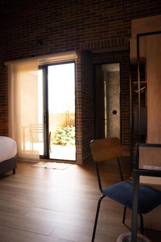 a room with a bed and a chair and a window at Casa Rose Hotel in Carmen de Viboral