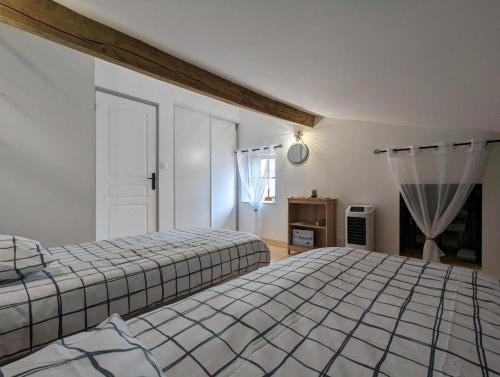 1 Schlafzimmer mit 2 Betten und einem Fenster in der Unterkunft Gîte La Rive Gauche in Saint-Même-les-Carrières