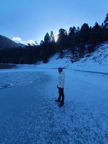 a person standing on a frozen river in the snow at azila _ issagun 
