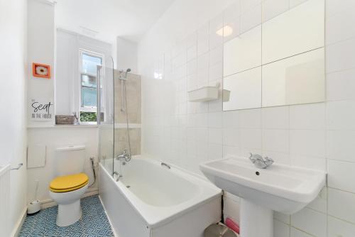 a white bathroom with a sink and a toilet at Spacious Maida Vale 2 Bed Apartment in London