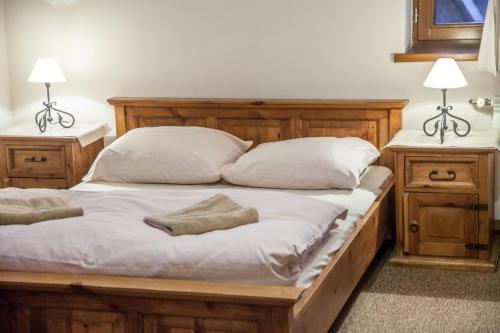 a wooden bed with two pillows and two night stands at Willa Litworówka in Biały Dunajec