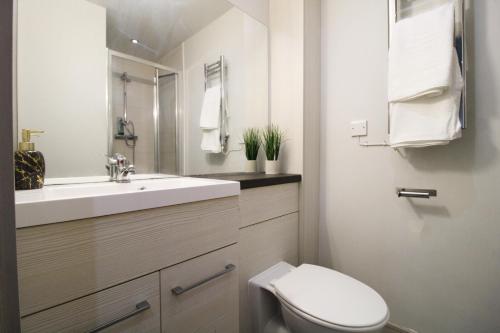 a white bathroom with a toilet and a sink at Lovely Studio Flat in Bolton in Bolton