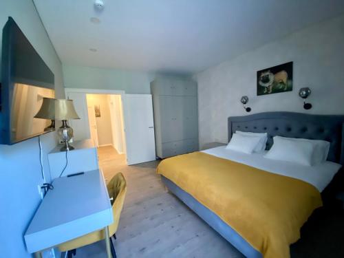 a bedroom with a large bed and a desk at Apartamentai Ornamentai in Druskininkai