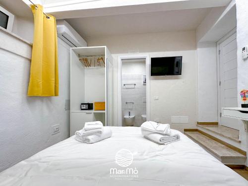 1 Schlafzimmer mit einem großen weißen Bett und einem Badezimmer in der Unterkunft MareMò Accomodations - Rooms in Tropea in Tropea