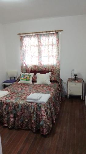 1 dormitorio con 1 cama con colcha de flores en VILLA LIDIA PLANTA ALTA en Mar del Plata