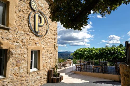 un edificio de piedra con un cartel en el costado en Domaine de la Pinède en Aubenas