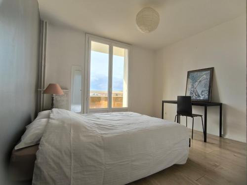une chambre avec un lit, un bureau et une fenêtre dans l'établissement Joli T2 lumineux avec balcon et wifi - proche CV, à Aix-en-Provence