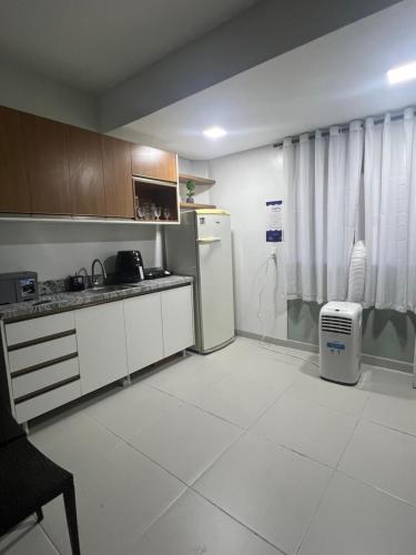 La cuisine est équipée d'un réfrigérateur et d'un évier. dans l'établissement Loft veraneio, à Balneário Camboriú
