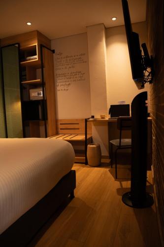a bedroom with a bed and a desk with a computer at Casa Rose Hotel in Carmen de Viboral