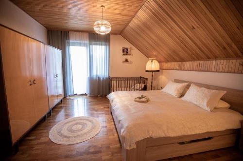 a bedroom with a large bed with a wooden ceiling at Holiday house On the riverside in Ogulin
