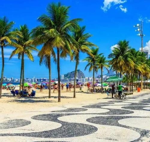 un paseo marítimo en una playa con palmeras en Apt Lindo e Aconchegante em Copacabana a 1 Quadra da Praia en Río de Janeiro
