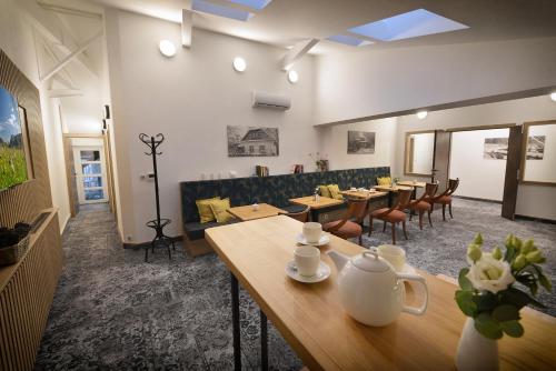jadalnia z drewnianymi stołami i krzesłami w obiekcie Vysocina Design Apartments w mieście Hlinsko