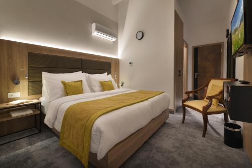 a hotel room with a large bed and a chair at Vysocina Design Apartments in Hlinsko