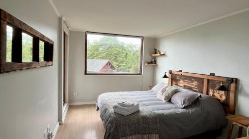 1 dormitorio con 1 cama y ventana grande en Vista al lago y excelente ubicación: hermoso depto, en Puerto Varas