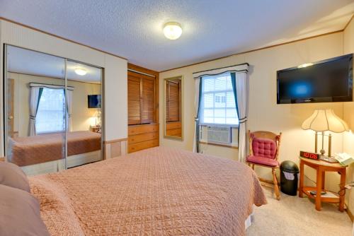 1 dormitorio con 1 cama, TV y silla en Cozy Lakemont Getaway, 11 Mi to Watkins Glen!, 
