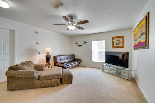 a living room with a couch and a flat screen tv at 22 Mi to Disney Kissimmee Home with Pool and Hot Tub in Kissimmee