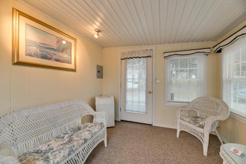 a room with white wicker chairs and windows at Quaint Lakemont Retreat 1 Mi to Seneca Lake! in Lakemont