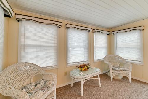 two wicker chairs and a table in a room with windows at Quaint Lakemont Retreat 1 Mi to Seneca Lake! in Lakemont